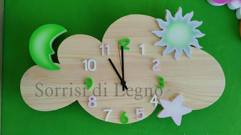 Orologio su nuvoletta grezza con applicazioni di sole, stella e luna colorate