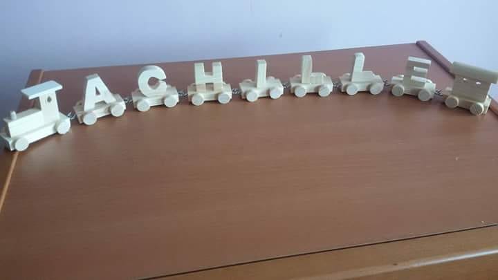 Trenino in legno composto con il nome di Achille, ogni vagone è un carattere